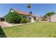 Well-maintained home exterior with green grass, garden, and mature landscaping at 10807 W Morten Ave, Glendale, AZ 85307
