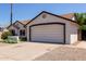 Home featuring a two-car garage, well-maintained landscaping, and mature foliage at 10807 W Morten Ave, Glendale, AZ 85307