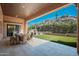 Expansive covered back patio with dining and seating, overlooking manicured backyard at 11070 E Bent Tree Dr, Scottsdale, AZ 85262