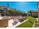 Relaxing backyard with built-in seating, fire pit, artificial grass, and mountain views at 11070 E Bent Tree Dr, Scottsdale, AZ 85262