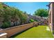 Landscaped backyard with artificial turf and rock wall, creating a private and tranquil outdoor retreat at 11070 E Bent Tree Dr, Scottsdale, AZ 85262