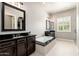 Elegant bathroom with double sinks, soaking tub, granite countertops, and modern fixtures at 11070 E Bent Tree Dr, Scottsdale, AZ 85262