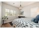 Bright bedroom with patterned bedding, hardwood floors, shutters, and modern chandelier at 11070 E Bent Tree Dr, Scottsdale, AZ 85262