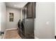 Well-lit laundry room with front-load washer/dryer, brick flooring, and upper cabinets at 11070 E Bent Tree Dr, Scottsdale, AZ 85262