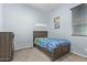 Well-lit bedroom features neutral carpeting, a window with blinds, and wooden furnishings at 12710 W Forest Pleasant Pl, Peoria, AZ 85383