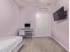 A bright bedroom with lilac-colored walls, white trim, and neutral carpeting, featuring a desk and closet at 12710 W Forest Pleasant Pl, Peoria, AZ 85383