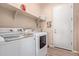Bright laundry room with front loading washer, dryer, and built-in shelving at 12710 W Forest Pleasant Pl, Peoria, AZ 85383