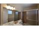 Well-lit bathroom with double sink, light fixtures, and walk-in shower with tile surround at 1414 W Monona Dr, Phoenix, AZ 85027
