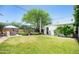 Well-maintained backyard featuring grass, mature shade trees, large saguaro cactus, and a seating area at 1441 E Hubbell St, Phoenix, AZ 85006