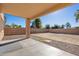 Covered back patio looking out to a large gravel backyard with block wall fence at 15611 W Cameron Dr, Surprise, AZ 85379