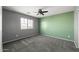 Comfortable carpeted bedroom with a ceiling fan and bright natural light from a window at 15611 W Cameron Dr, Surprise, AZ 85379