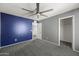 Well-lit bedroom featuring gray and blue walls, plush carpet, and a ceiling fan for added comfort at 15611 W Cameron Dr, Surprise, AZ 85379