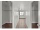 Bright hallway with white walls, tile floors, and views of various rooms including bedrooms and a bathroom at 15611 W Cameron Dr, Surprise, AZ 85379