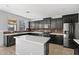 Stylish kitchen boasts black cabinets, stainless appliances, a white island, and bright natural light at 15611 W Cameron Dr, Surprise, AZ 85379