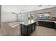 Modern kitchen features black cabinets, tile floors, a white countertop island, and stainless steel appliances at 15611 W Cameron Dr, Surprise, AZ 85379