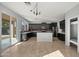 Open concept kitchen features black cabinets, stainless appliances, an island, and patio access at 15611 W Cameron Dr, Surprise, AZ 85379
