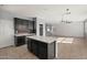 Modern kitchen with black cabinets, island, and adjacent dining area featuring shiplap wall at 15611 W Cameron Dr, Surprise, AZ 85379