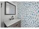 Stylish powder room featuring a modern vanity and patterned accent wall at 15611 W Cameron Dr, Surprise, AZ 85379