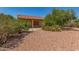 View of the desert landscaped backyard with patio and greenery. The house has a tile roof at 15980 W Quail Creek Ln, Surprise, AZ 85374