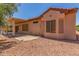 Backyard view showing patio and the house with desert landscaping and a rock covered ground at 15980 W Quail Creek Ln, Surprise, AZ 85374