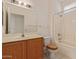 Bathroom featuring wood cabinets, single sink, toilet, and a shower-tub combination with tile surround at 15980 W Quail Creek Ln, Surprise, AZ 85374
