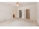 Spacious bedroom featuring a ceiling fan and multiple entryways to a bathroom and closets at 15980 W Quail Creek Ln, Surprise, AZ 85374
