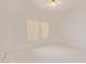 Bright bedroom featuring neutral walls, neutral carpet, a ceiling fan and a large window at 15980 W Quail Creek Ln, Surprise, AZ 85374