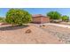 Well-maintained front yard featuring mature trees, desert landscaping, and a terracotta-tiled roof home at 15980 W Quail Creek Ln, Surprise, AZ 85374