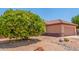 Mature tree provides shade in this desert landscape in front of this well-maintained home at 15980 W Quail Creek Ln, Surprise, AZ 85374