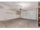 Spacious two car garage features a rolling door, shelves for storage, and a concrete floor at 15980 W Quail Creek Ln, Surprise, AZ 85374