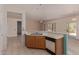 Modern kitchen with tile flooring and stainless steel dishwasher overlooking spacious living area at 15980 W Quail Creek Ln, Surprise, AZ 85374