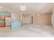 Open living area with breakfast bar, ceiling fans, and neutral carpeting at 15980 W Quail Creek Ln, Surprise, AZ 85374