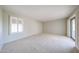 Bright bedroom with neutral carpet, large windows, and sliding glass doors to the exterior at 1844 W Virginia Ave, Phoenix, AZ 85007