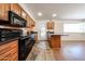 Kitchen with black appliances, wood cabinets, breakfast bar, and stone-style flooring at 1844 W Virginia Ave, Phoenix, AZ 85007