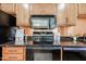 Kitchen featuring modern appliances, granite countertops, and wood cabinets at 1844 W Virginia Ave, Phoenix, AZ 85007