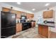 Bright kitchen with black appliances, stone tile flooring, and wood cabinets at 1844 W Virginia Ave, Phoenix, AZ 85007