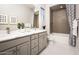Bright bathroom with double sinks, quartz countertops, patterned tile in the shower and stylish fixtures at 22673 E San Tan Blvd, Queen Creek, AZ 85142