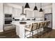 Bright kitchen featuring stainless steel appliances, quartz countertops, and a large center island with seating at 22673 E San Tan Blvd, Queen Creek, AZ 85142
