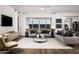 Open-concept living room featuring hardwood floors, large windows, modern decor, and neutral color palette at 22673 E San Tan Blvd, Queen Creek, AZ 85142