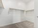 Spacious walk-in closet with carpet, featuring wooden hanging rods and shelving for optimal organization at 31476 N Hayweather Ln, San Tan Valley, AZ 85143