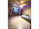 Spacious bedroom with tile flooring and a ceiling fan, offering versatility and comfort for personal living at 3937 W Stella Ln, Phoenix, AZ 85019