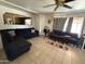 Inviting living room featuring tile flooring, a comfortable sectional sofa, and a ceiling fan for added comfort at 3937 W Stella Ln, Phoenix, AZ 85019