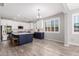 Bright kitchen featuring white cabinets, a navy blue island, stainless steel appliances and wood-look floors at 40913 W Williams Way, Maricopa, AZ 85138