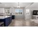 Eat-in kitchen featuring white upper cabinets, a navy blue island and gray wood-look floors at 40913 W Williams Way, Maricopa, AZ 85138