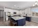 Well-equipped kitchen featuring white upper cabinets, stainless steel appliances, and a navy blue island at 40913 W Williams Way, Maricopa, AZ 85138