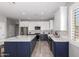 Bright kitchen featuring white cabinets, a navy blue island, stainless steel appliances and wood-look floors at 40913 W Williams Way, Maricopa, AZ 85138