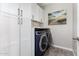 Laundry room featuring white cabinets and modern blue washer and dryer at 40913 W Williams Way, Maricopa, AZ 85138