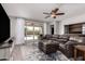 Spacious living room with sliding glass doors to the pool, wood-look floors and a ceiling fan at 40913 W Williams Way, Maricopa, AZ 85138