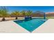 Desert backyard pool featuring a tanning ledge and blue tile waterfall feature with surrounding palm trees at 40913 W Williams Way, Maricopa, AZ 85138
