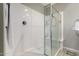 Modern walk-in shower featuring glass doors and clean, white tile walls at 40913 W Williams Way, Maricopa, AZ 85138